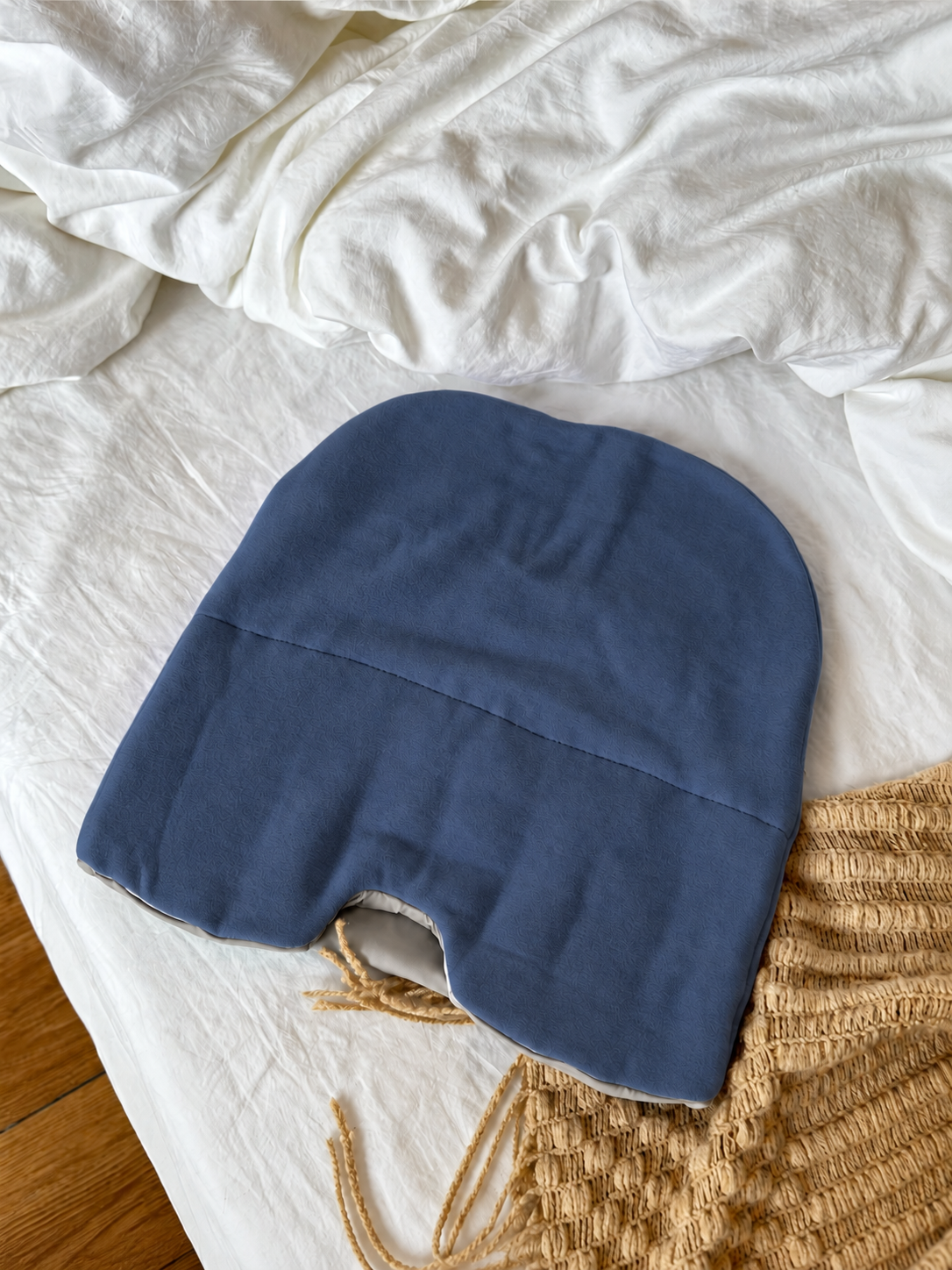 Blue weighted sleep hood laid on a bed